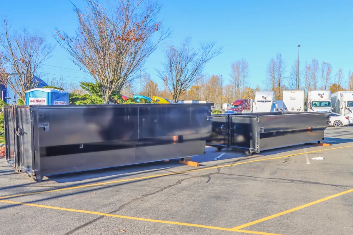 Professional dumpster rental service with roll-off container on residential driveway in Fort Riley